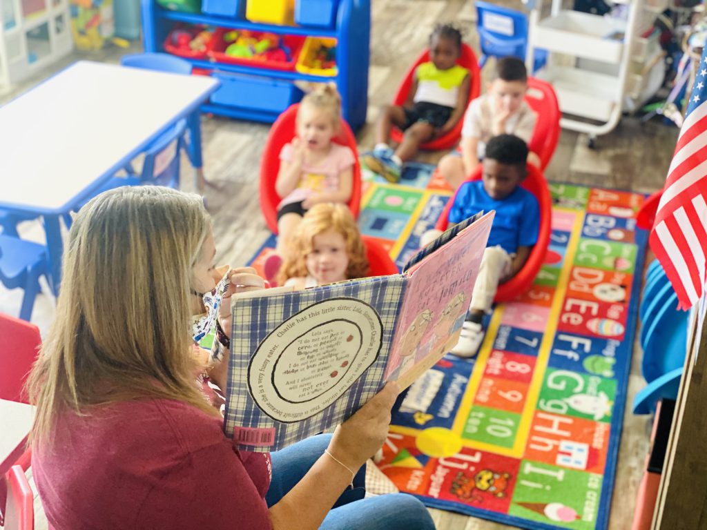 Just In Time staff member reads to children during program day